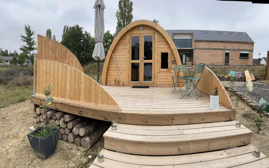 eine große Holzterrasse mit einem Tisch darauf in der Unterkunft La cabane de l'étang 