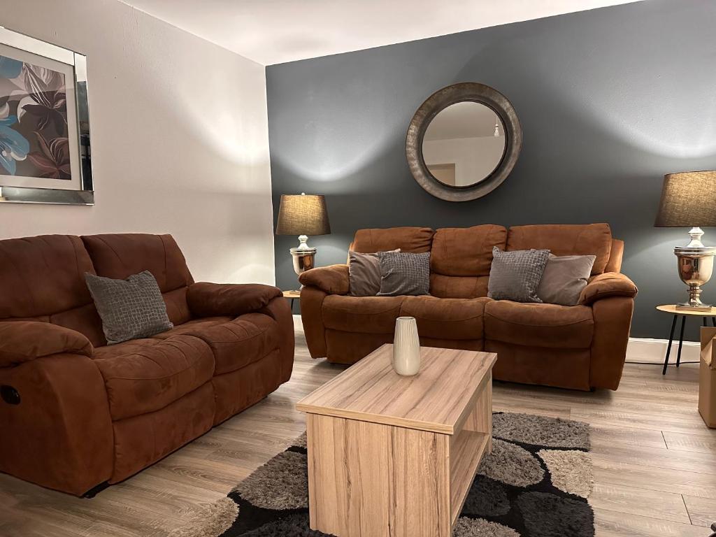 a living room with two brown couches and a table at Crown street getaway in Ayr