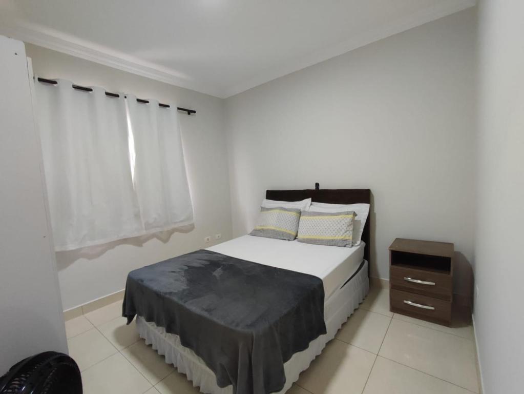 a white bedroom with a bed and a window at Residencia Cidade Verde 14 in Maringá