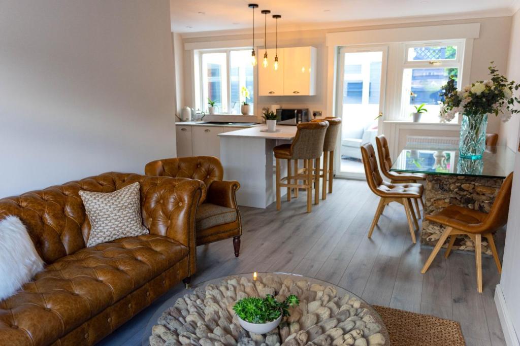 ein Wohnzimmer und eine Küche mit einem Sofa und einem Tisch in der Unterkunft Lovely 2 bed house in Pitlochry in Pitlochry