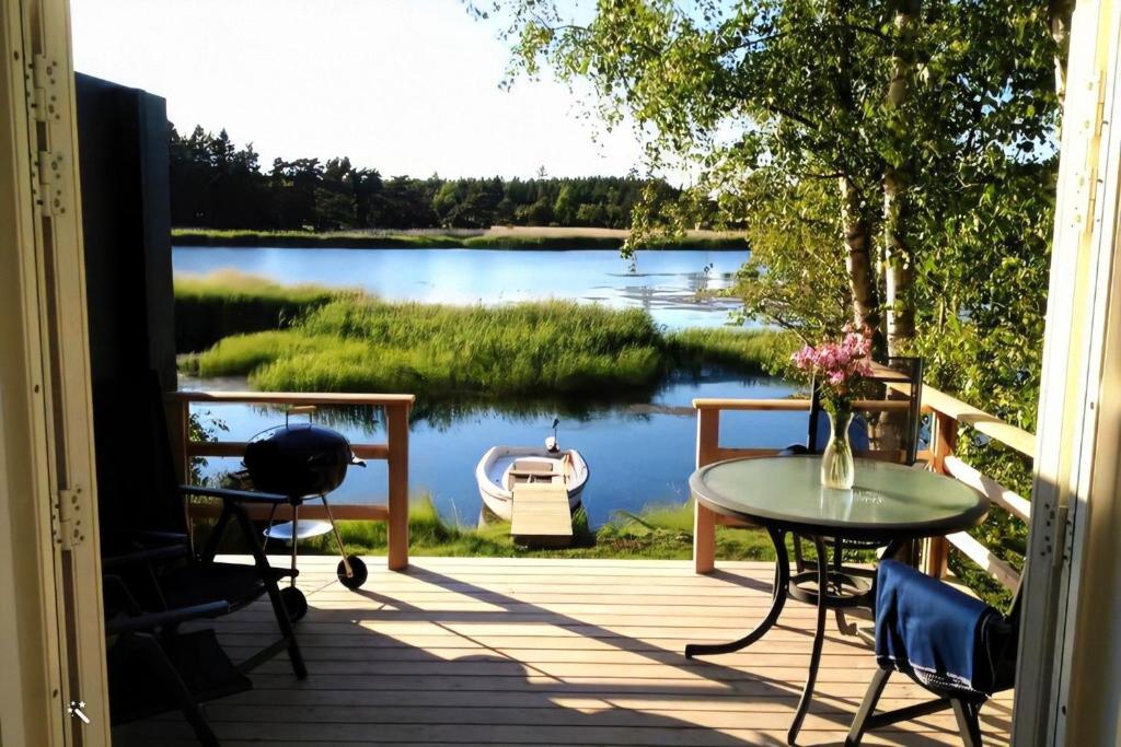 een uitzicht op een meer vanaf de veranda van een huis bij Sjöstugan, Solviken in Rockneby
