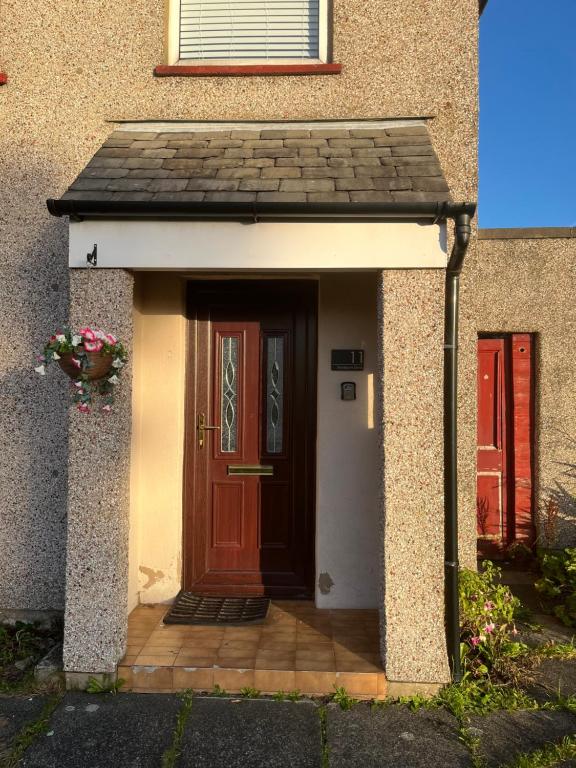 a house with a brown door and a flower pot at 'Melrose' at stayBOOM in Lancaster