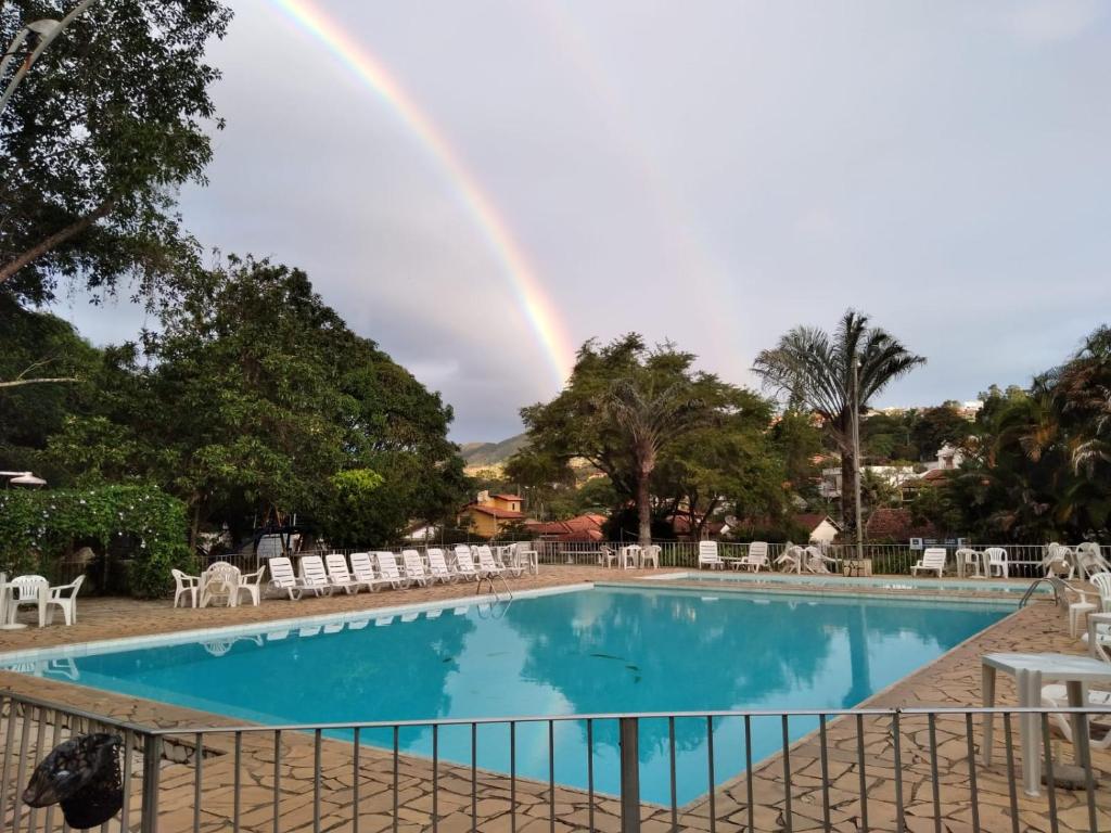 un arco iris sobre una piscina con arco iris en Hotel Miguel Pereira, en Miguel Pereira