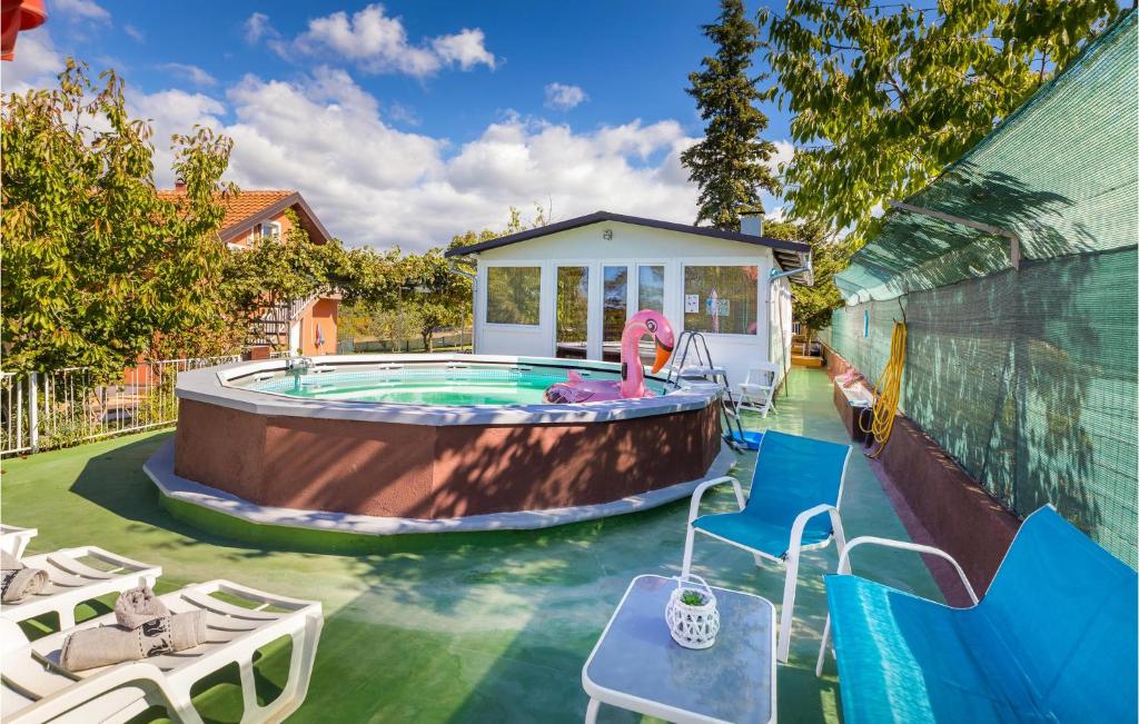 a backyard with a pool with a girl playing in it at Gorgeous Home In Vodnjan With Wifi in Vodnjan