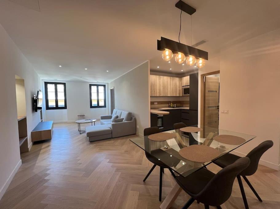 a living room with a dining table and a kitchen at Place Massena, superbe appartement neuf. in Nice