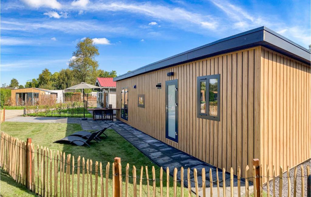a small building with a fence next to a yard at Stunning Home In Heinkenszand With Wifi in Heinkensand