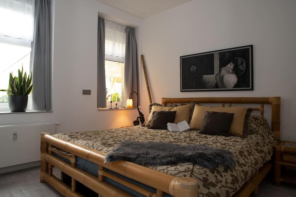 een slaapkamer met een groot bed met een houten frame bij NEU Luxus-Wasserbett-SmartTV-Terrasse-2Schlafzimmer in Maagdenburg