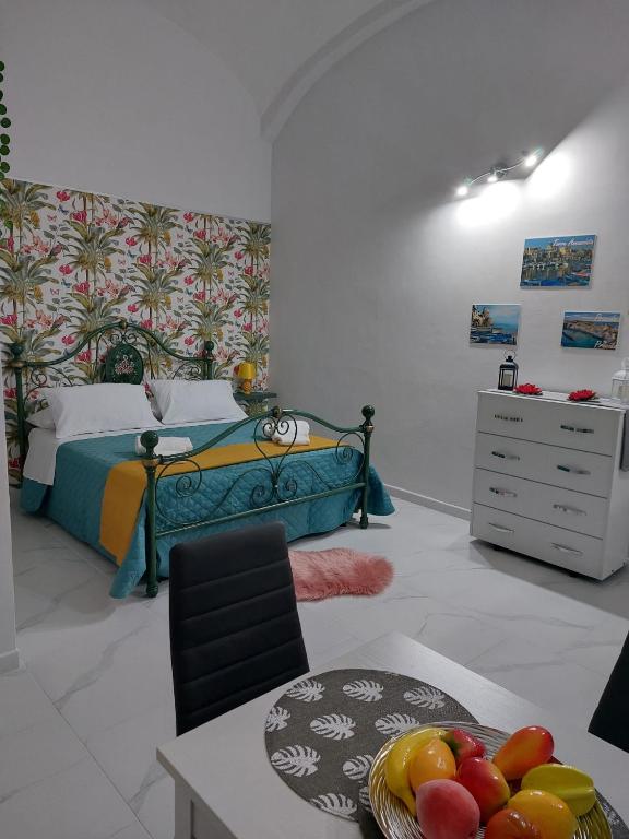 sypialnia z łóżkiem i stołem z misą owoców w obiekcie Casa TeKa w mieście Torre Annunziata