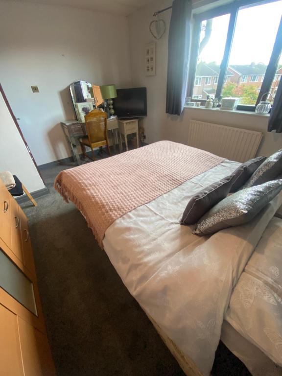 ein Schlafzimmer mit einem Bett mit Kissen und einem Fenster in der Unterkunft Rode house home stay in Rode Heath