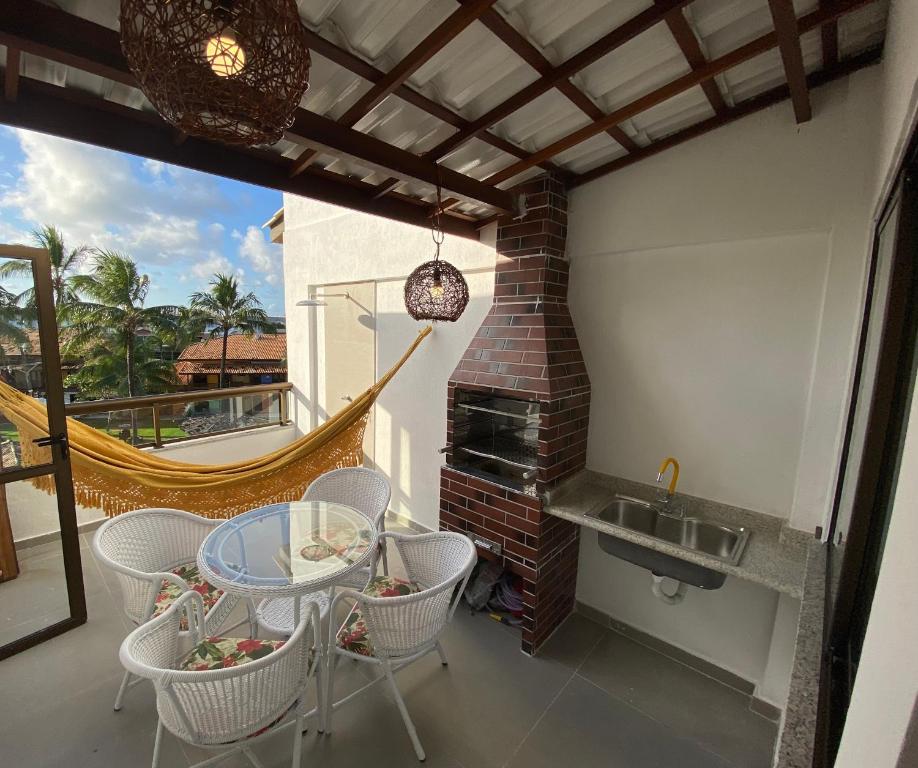 een patio met een tafel en stoelen op een balkon bij Apartamento Cobertura Paraíso das Águas - GUARAJUBA in Camaçari