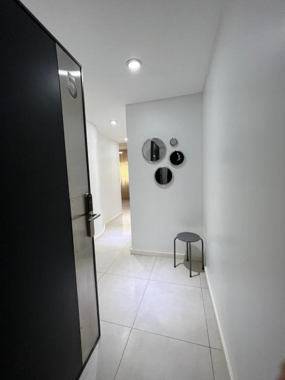 a hallway with a black door and a stool at Wehome Buenos Aires in Buenos Aires