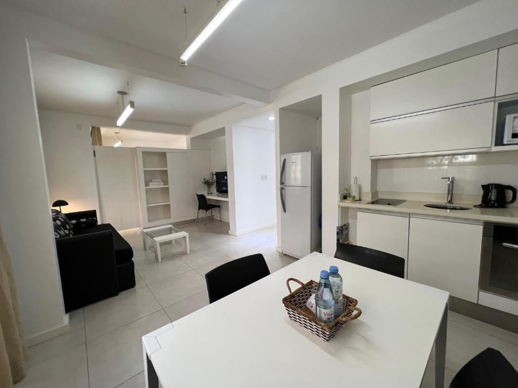 una cucina e un soggiorno con tavolo e sedie bianchi di Wehome Buenos Aires a Buenos Aires