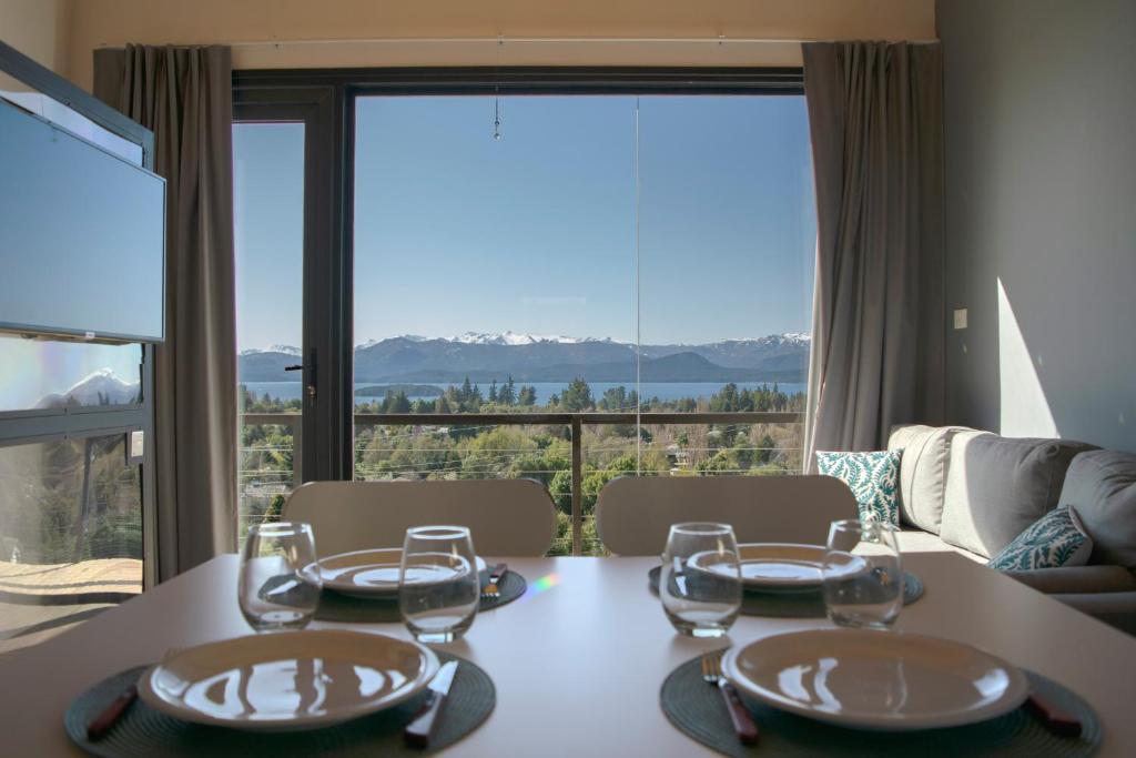 a dining room table with a view of the mountains at V&P Apt in San Carlos de Bariloche
