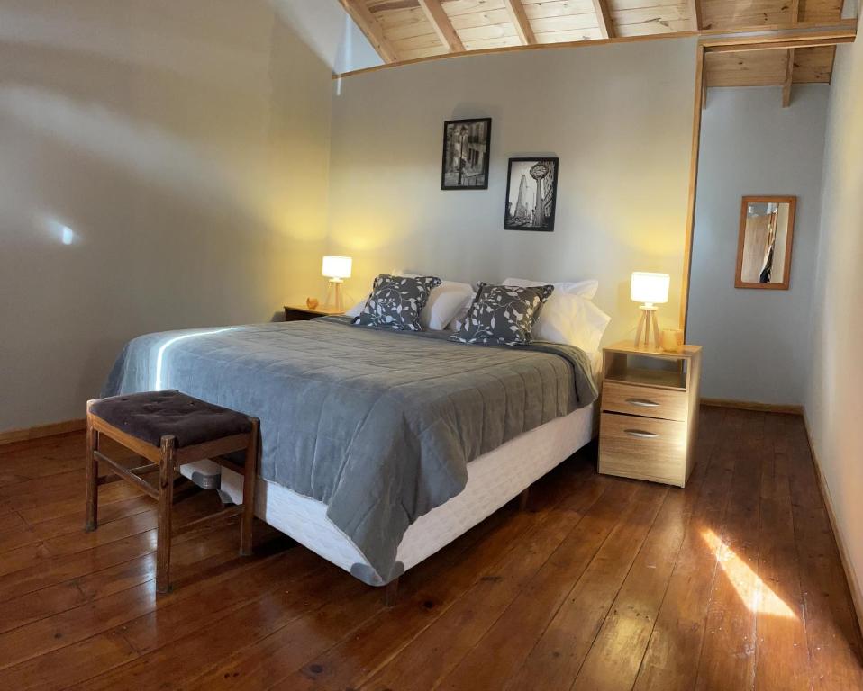 1 dormitorio con 1 cama grande y suelo de madera en Hermosa y confortable casita en Bariloche en San Carlos de Bariloche