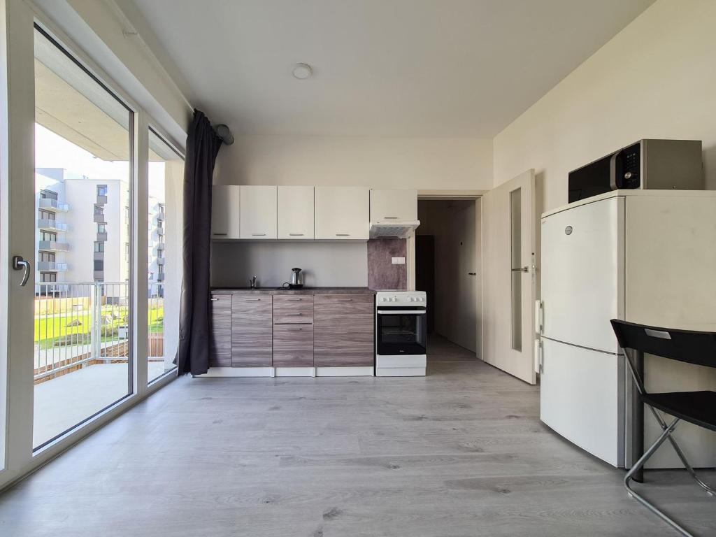 kuchnia z białą lodówką i dużym oknem w obiekcie Cozy and modern apartment near Brno city center w mieście Husovice