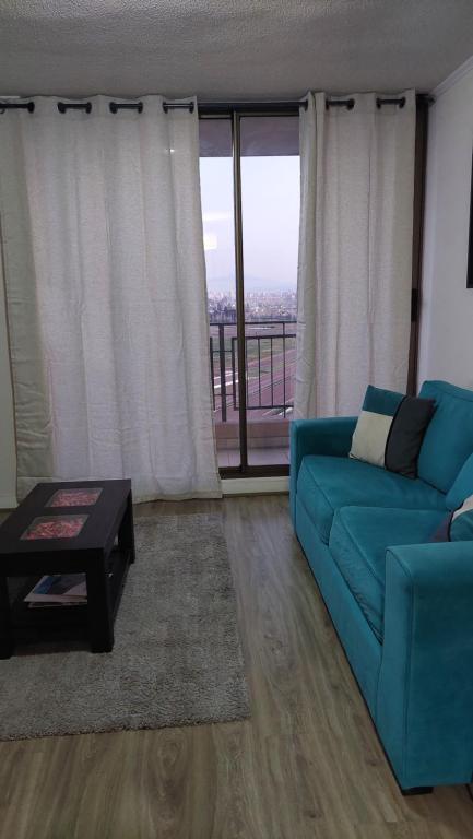 sala de estar con sofá azul y mesa en departamento santiago centro frente club hipico y movistar arena, en Santiago