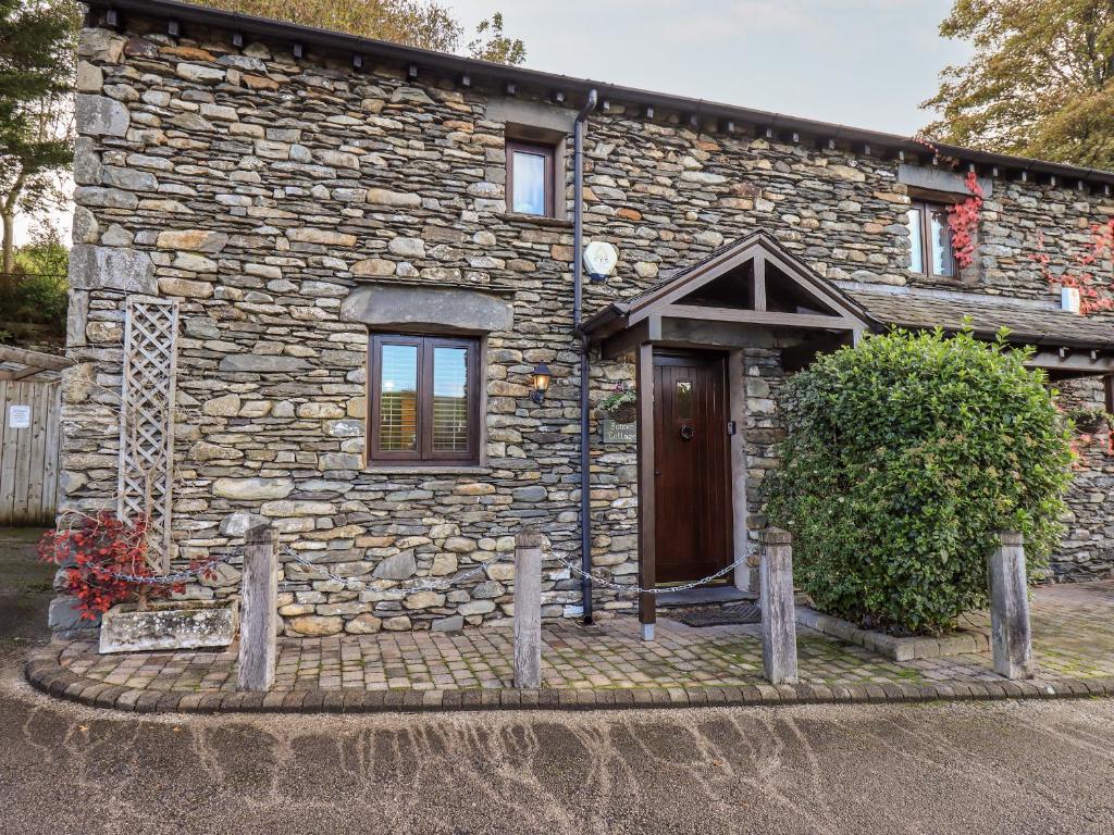 a stone house with a wooden door in front of it at Bobbin Cottage in Staveley