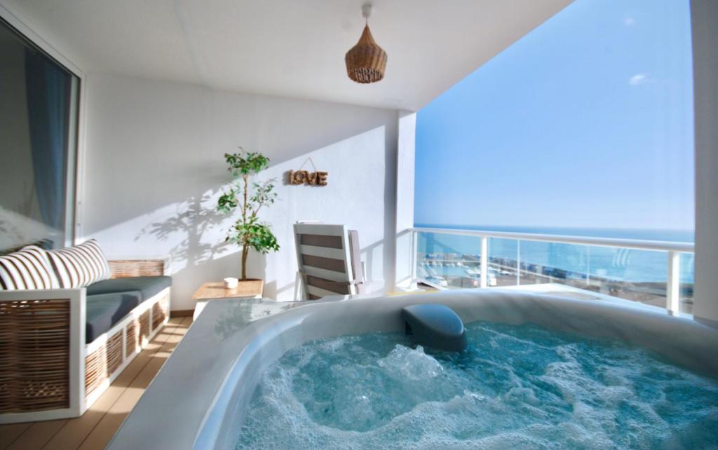 a hot tub in a room with a view of the ocean at Sailor Lovers - Jacuzzi Fuerteventura in Gran Tarajal