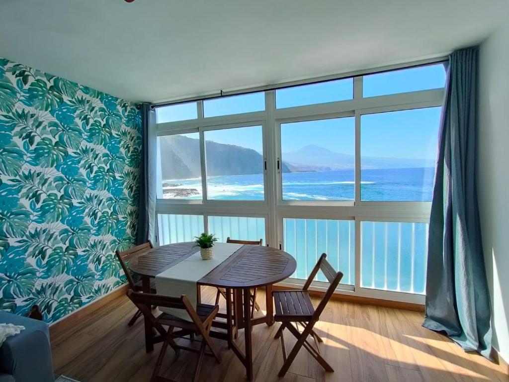 ein Esszimmer mit einem Tisch und Stühlen sowie einem großen Fenster in der Unterkunft Beautiful beach in Santa Cruz de Tenerife