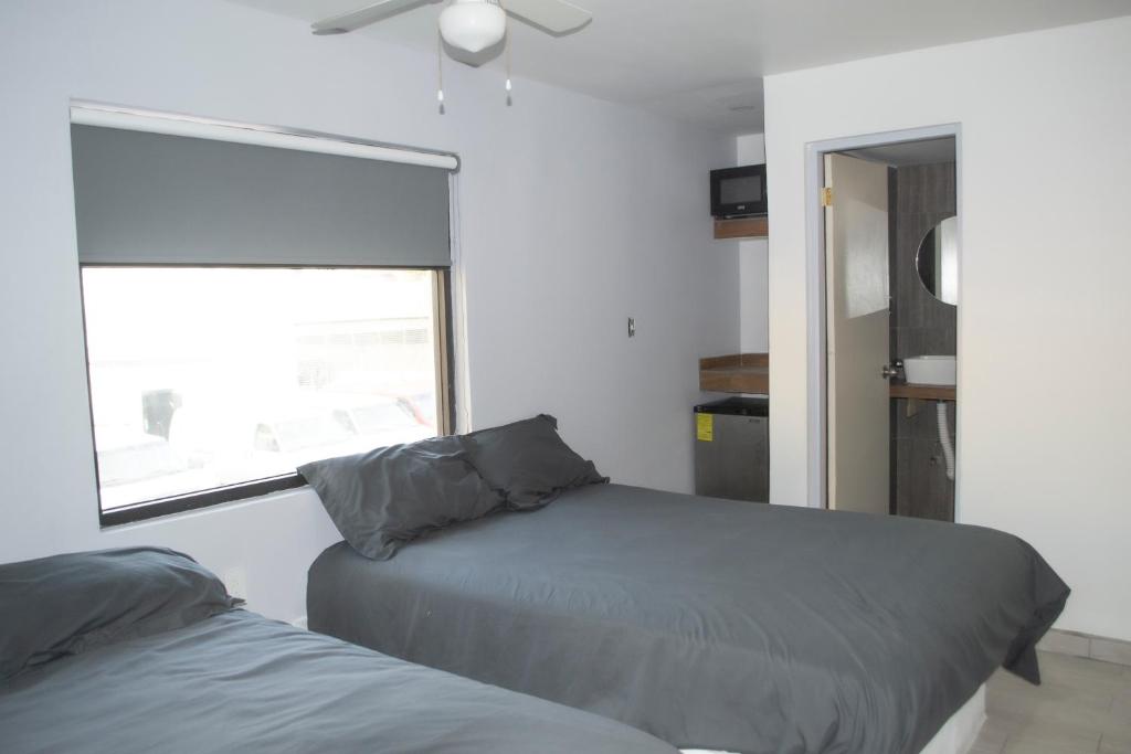 1 dormitorio con 2 camas y ventana en APARTAMENTOS AMBASSADOR, en Tijuana