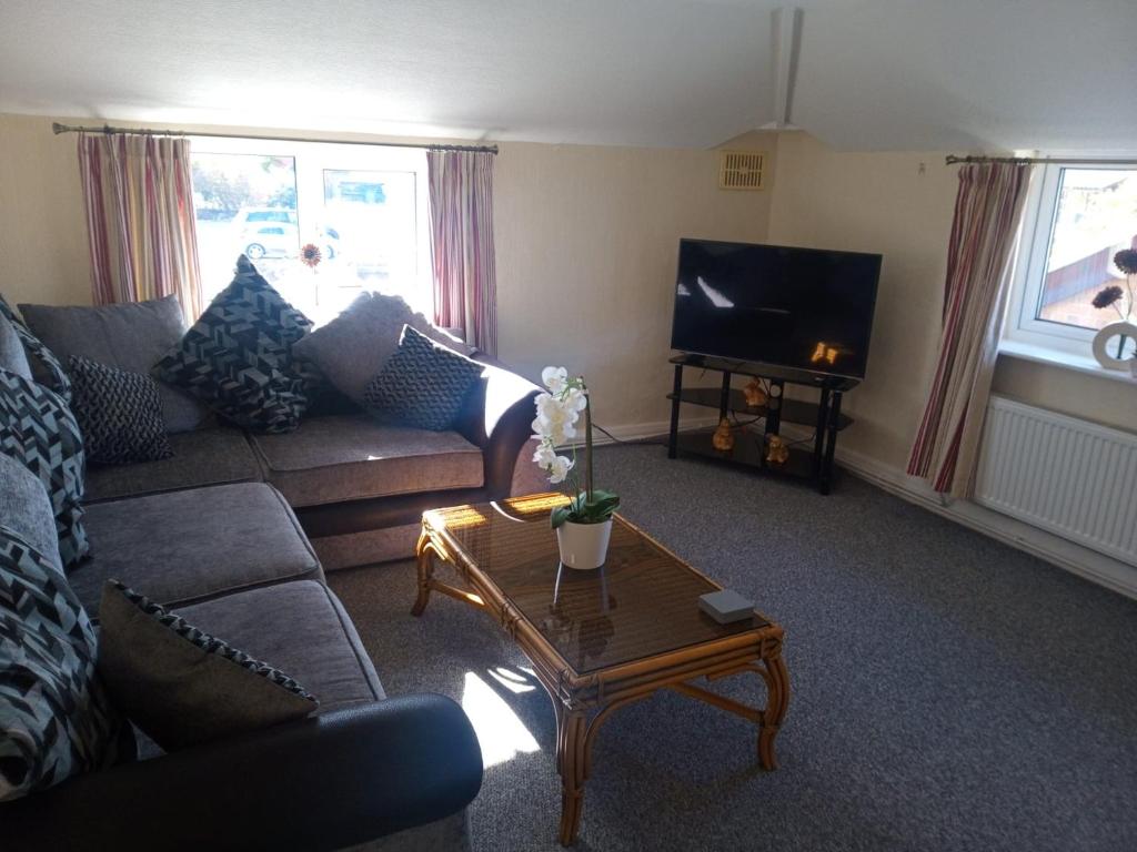 a living room with a couch and a coffee table at Fox and Hounds Apartment in Willingham