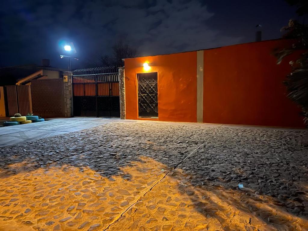 an orange building with a door at night at Entre Cava y Cata in Ica