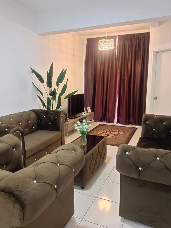 a living room with two couches and a table at D'Irish Homestay Wakaf Che Yeh in Kota Bharu