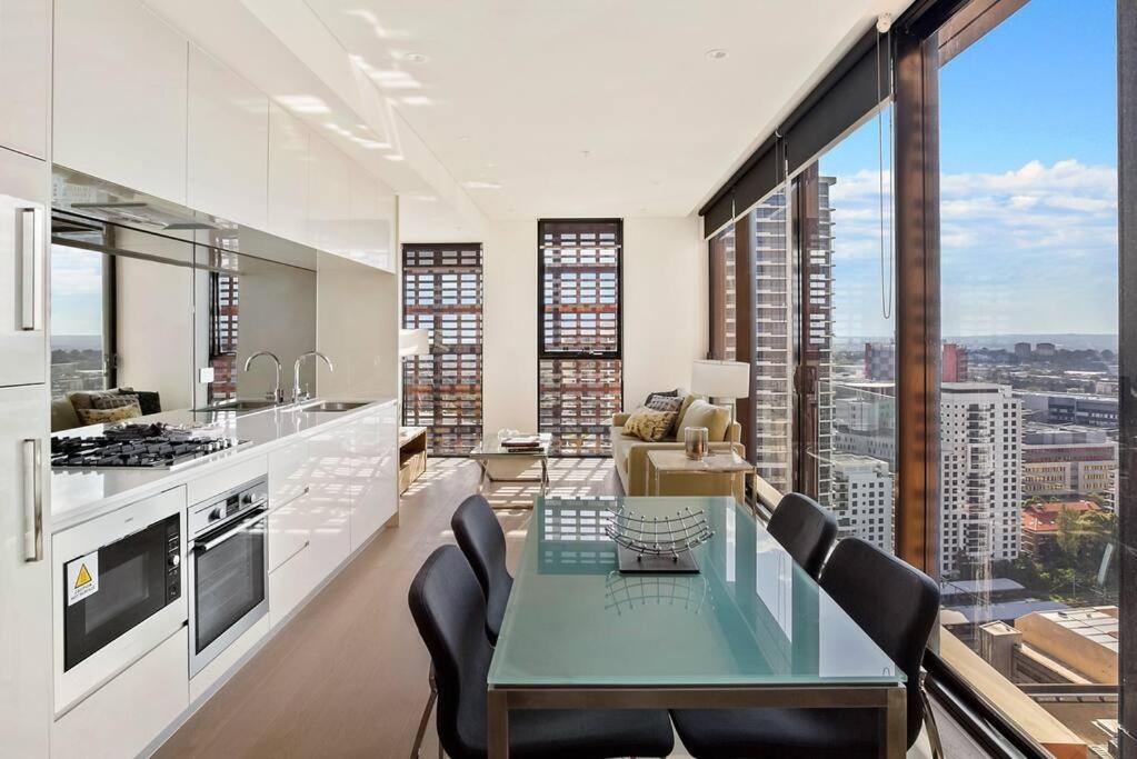 uma cozinha e sala de estar com mesa e cadeiras em Beautiful one bedroom apartment in St Leonards-ATC62209 em Sydney