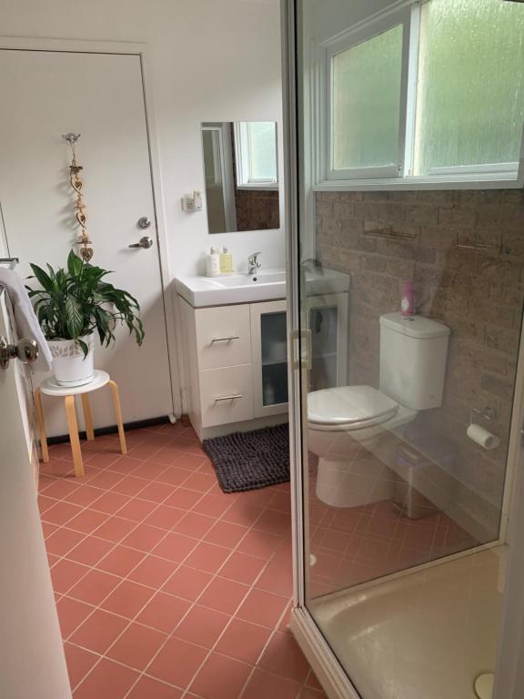 y baño con ducha, aseo y lavamanos. en Large relaxing light filled room in Bowral, en Bowral