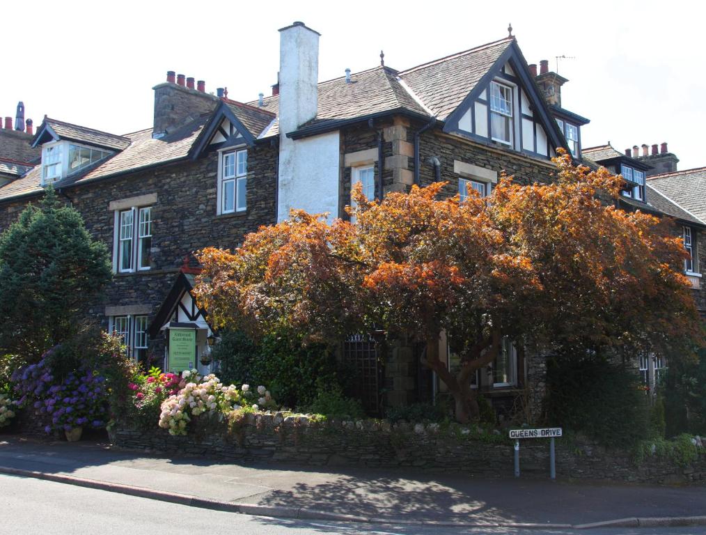 una gran casa de ladrillo con un árbol delante en Kirkwood Guest House, en Windermere