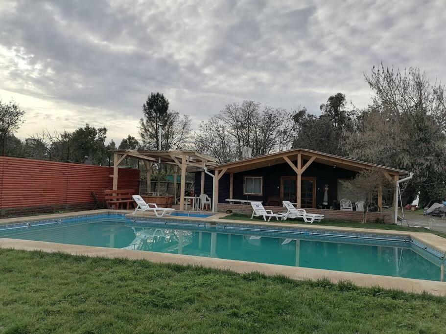 una casa con piscina en el patio en Agradable Cabaña con Gran Piscina y Tinaja, en Quillón