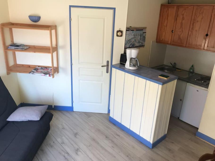 Zimmer mit einer Küche mit einer Tür und einer Theke in der Unterkunft Baréges : Appartement Résidence de l’Ayré in Barèges