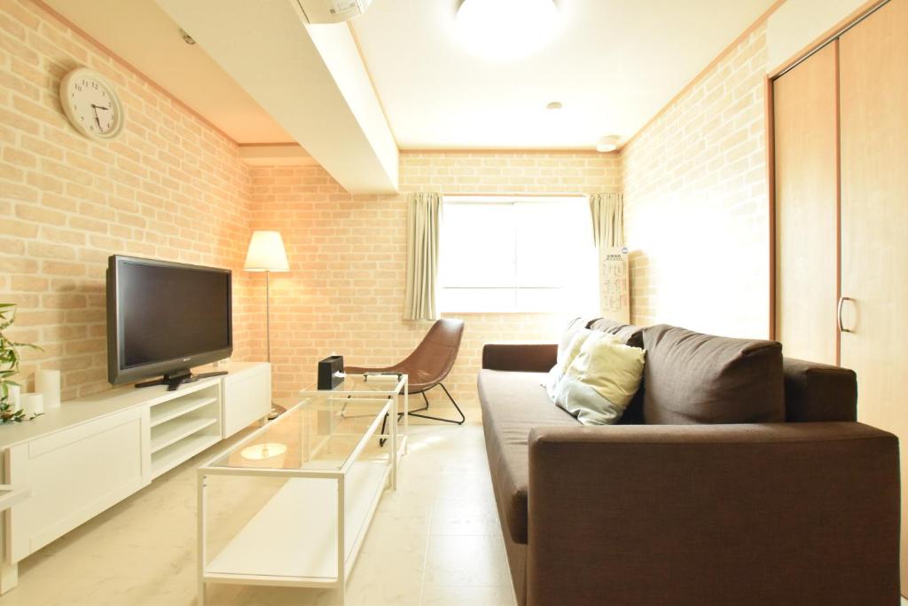 - un salon avec un canapé et une télévision dans l'établissement Nippombashi kaikan 605, à Osaka
