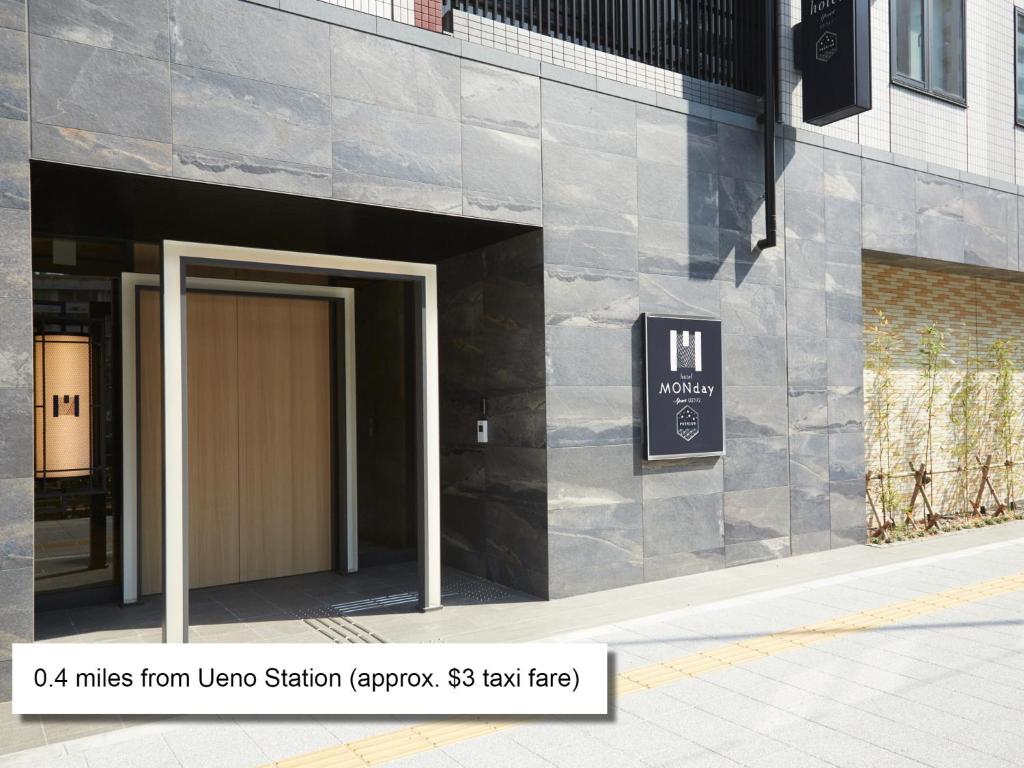 a entrance to a building with a brown door at MONday Apart Premium UENO in Tokyo
