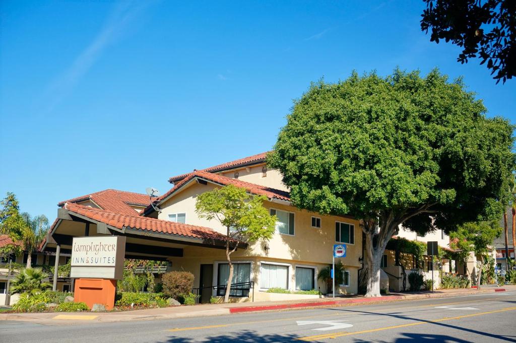 a building with a tree on the side of a street at Lamplighter Inn & Suites in San Luis Obispo