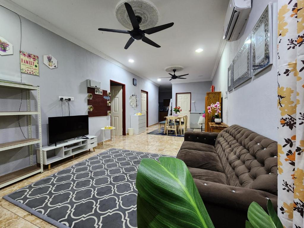 uma sala de estar com um sofá e uma ventoinha de tecto em MK Homestay em Butterworth