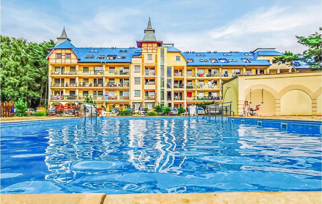 a hotel with a swimming pool in front of a building at 3 Bedroom Lovely Apartment In Lukecin in Łukęcin