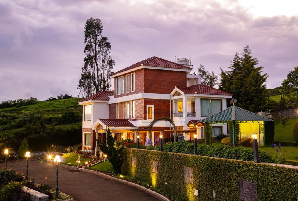 a house on a hill with a driveway at Western Valley Resorts in Ooty