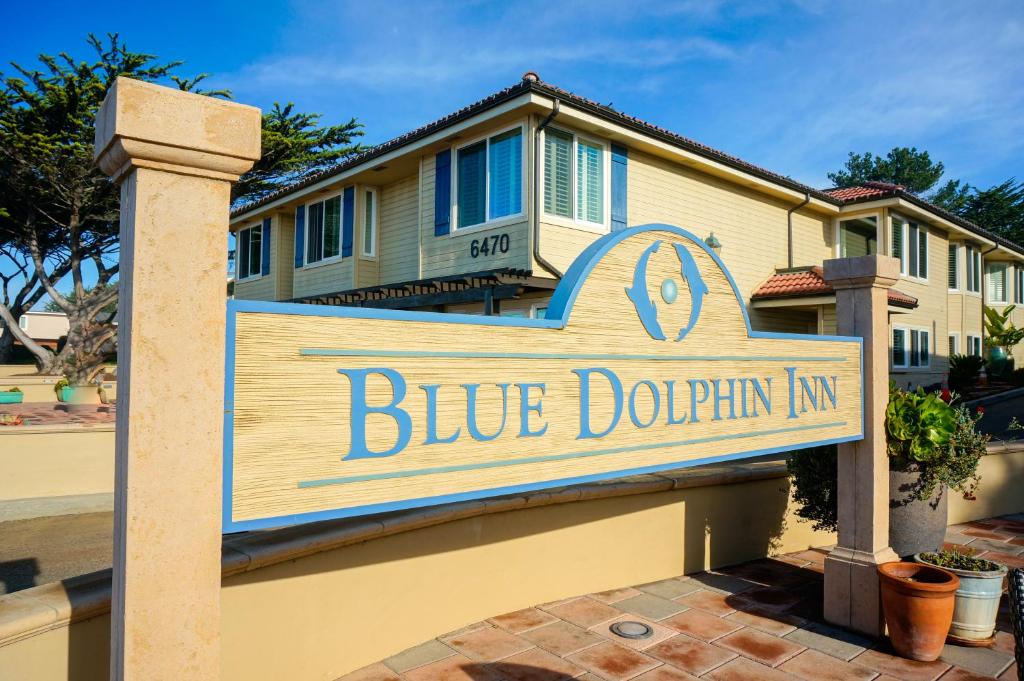 Un cartel azul de posada de delfines frente a una casa en Blue Dolphin Inn, en Cambria