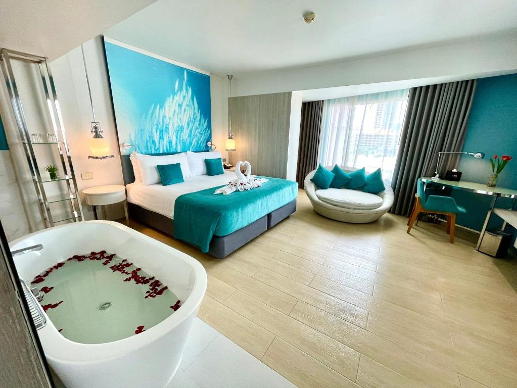 a hotel room with a bed and a bath tub at Kudos Parc Pattaya in Pattaya South