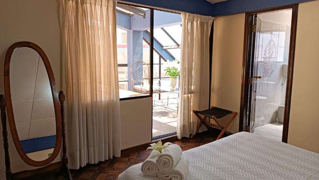a bedroom with a bed and a mirror and a balcony at Elegance Hotel in La Paz
