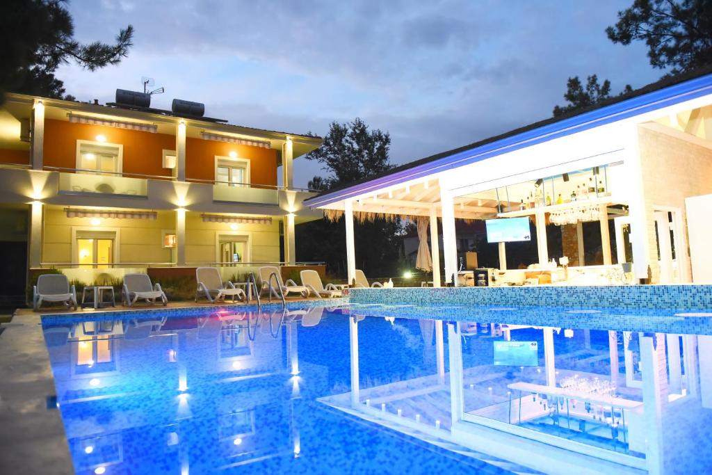 a large swimming pool in front of a house at Laida studios in Prinos