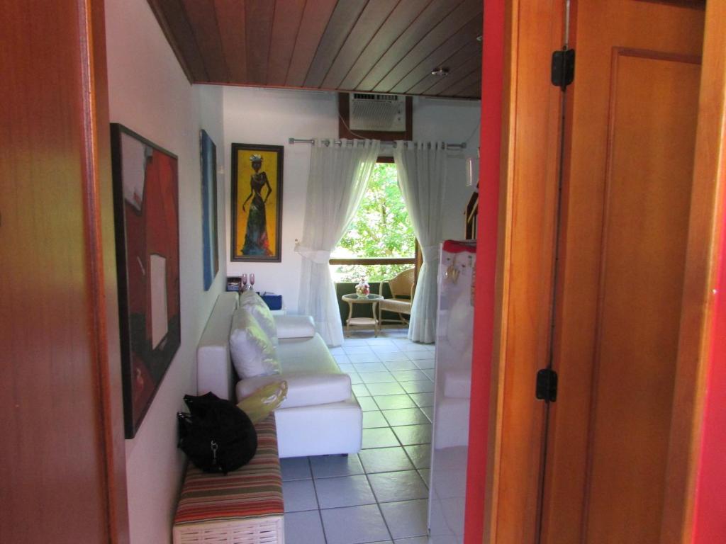 una habitación con 2 sofás blancos y una ventana en Condomínio Armazém Da Vila - apt 03, en Praia do Forte