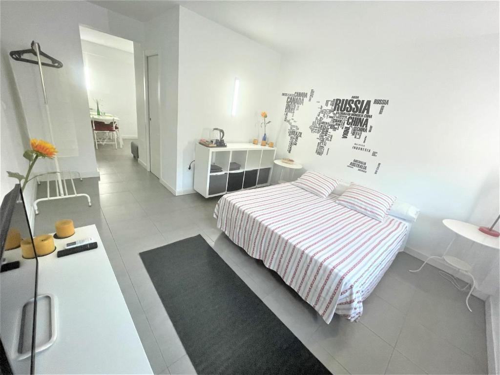 a white bedroom with a bed and a desk at Plaza de toros / Centro in Málaga