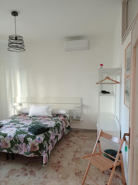 a bedroom with a bed and a wooden chair at CasaRA in Bari