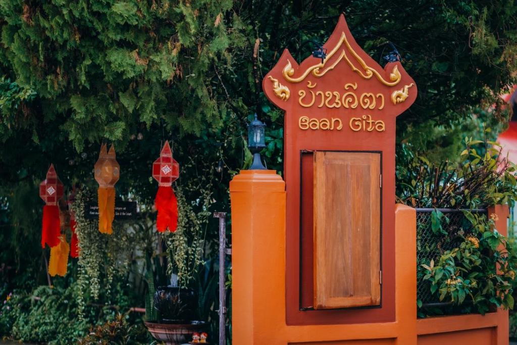 un signo anaranjado con un signo para un emplazamiento de genes gandanandanandanandan en Gita's House, en Chiang Rai