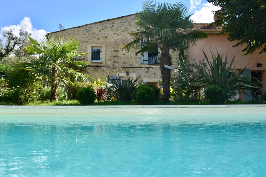 a house with palm trees and a swimming pool at Gites Lydil in Nyons