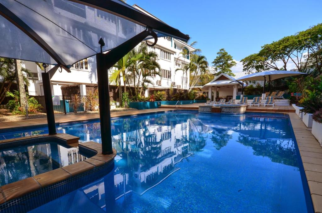 a large swimming pool with a balcony overlooking the ocean at BeachView Apartments at Villa Paradiso in Palm Cove