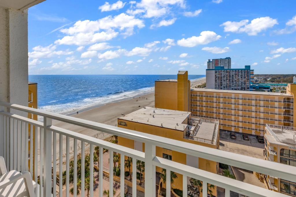 a balcony with a view of the beach and buildings at SeaMist Driftwood Vacation Studio with Balcony in Myrtle Beach