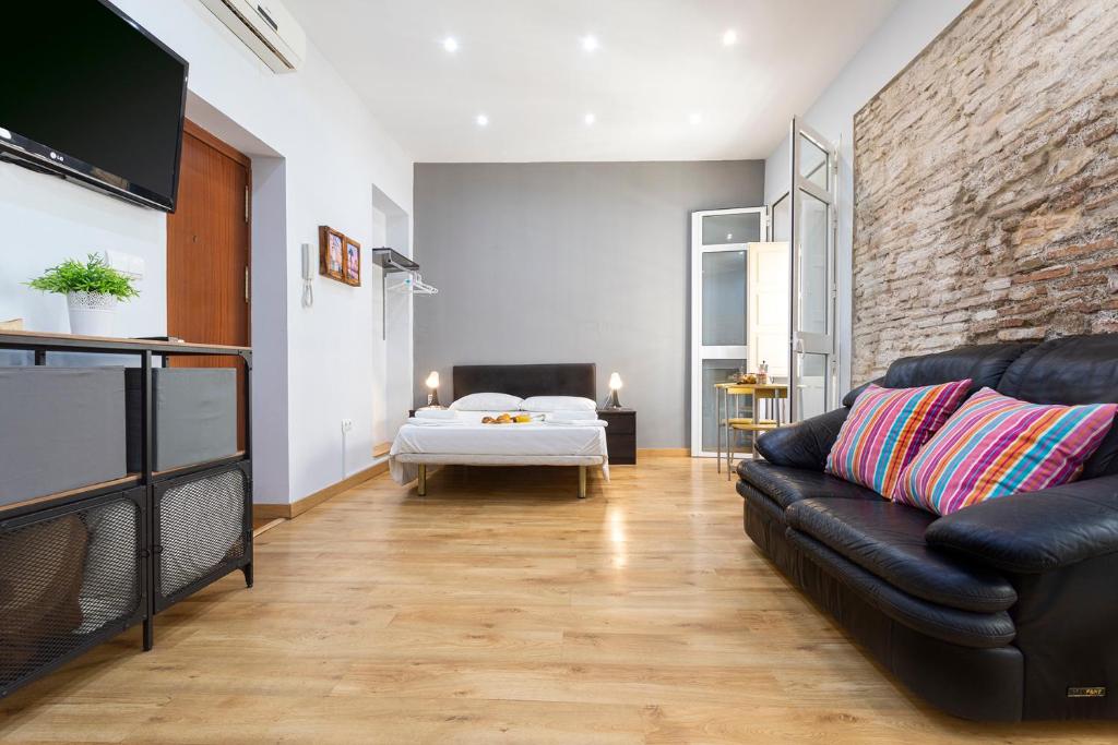 - un salon avec un canapé et un lit dans l'établissement Livemalaga Letrán Apartment, à Malaga